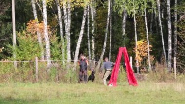 İki adam köpek doberman saklanmak için çadır ile çayırda tren