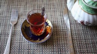 Tabak, çatal, bıçak ve masada demlik çay bardak.