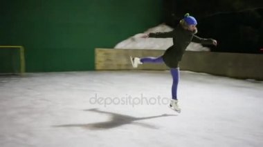 Kız teen kaymaktadır - çalışır ve buz pistinde kış geceleri atlar