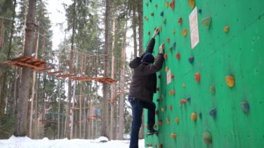 Adam kış gününde tırmanma için özel duvara tırmanıyor