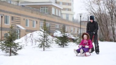 Mutlu çocuk iter kızak pembe kar yağışı sırasında kızla