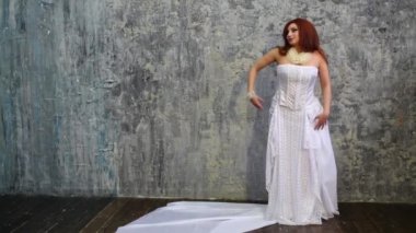 Beyaz elbise dansları Studio duvarının yakınında güzel kadın
