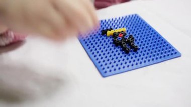 El çocuğun parlak plastik mozaik beyaz masada oynayın.
