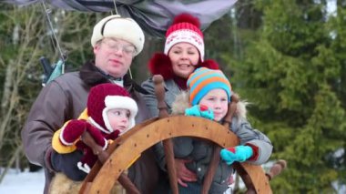 Mutlu anne, baba ve iki çocuk kış direksiyon simidi ile oynamak