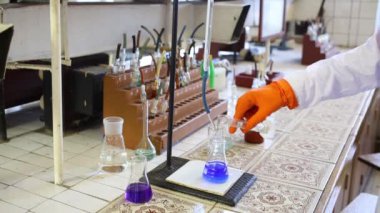 Erkek karışımları bagajinda sıvı şişeye laboratuvar eldiven eller. Şişe üzerinde metin: murexide