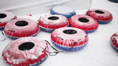 Birçok parlak snowtubes ve kar yağışı sırasında adamın vücut parçası