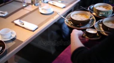 Garson masaya tabak yemek tepsisi ve koyar alarak elinde