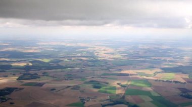 Airplane flies right under the layer of cumulus clouds.