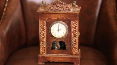 Sarkaç deri koltuk üzerinde sallanan ile küçük ahşap saat.