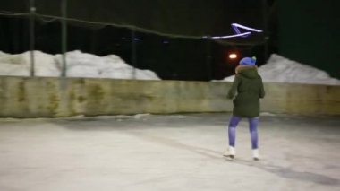 Kız teen kaymaktadır - çalışır ve buz pistinde kış geceleri trenler