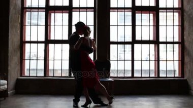 Kırmızı elbiseli kadın ve erkek siyah takım elbise dans tango yakınındaki penceresi