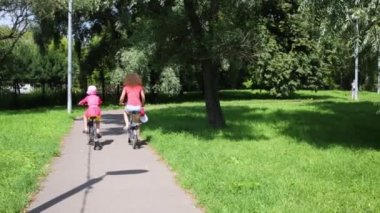 Anne ve kızı Bisiklet Park güneşli bir yaz