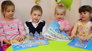Moskova, Rusya - 28 Nisan 2015: Dört çocuk masaya otur ve İngilizce ders kitapları açmak
