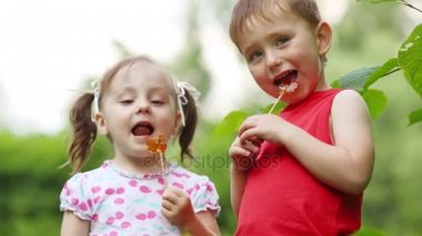 Küçük sevimli küçük kız ve çocuk yaz Park lolipop yalamak