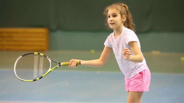幸せな女の子テニス練習中にボールを撃退することを学ぶ — ストック動画