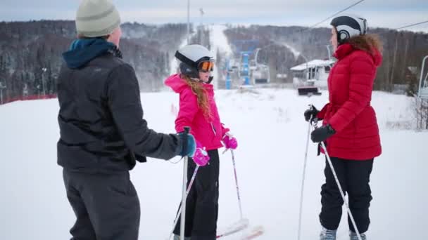 Жінка з дітьми катається на лижах взимку на гірськолижному курорті — стокове відео