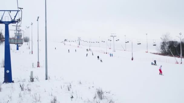 Kabelbaan, skiërs en snowboarders op de afdaling op de winter — Stockvideo