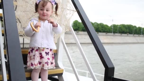 Kleines Mädchen Steht Mit Regenschirm Auf Der Treppe Des Schiffes — Stockvideo