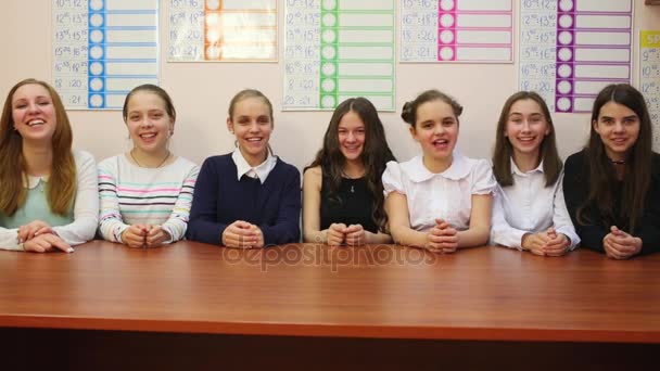 Zeven Vrolijke Schoolmeisje Zit Aan Tafel Verlaagd Hun Handen Onder — Stockvideo