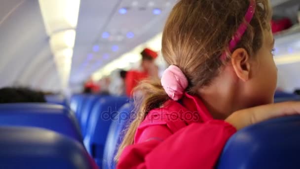 Zbliżenie Uśmiechając Się Trochę Dziewczynka Fale Ręka Siedzący Kabinie Samolotu — Wideo stockowe