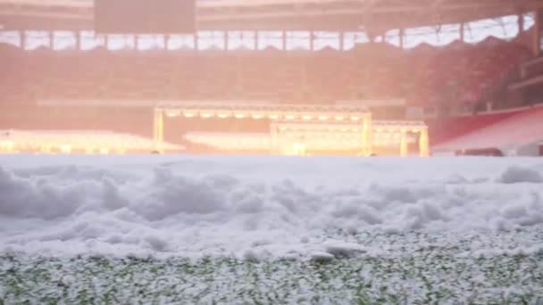 ランプ サッカー スタジアムで緑の野原に積もった雪のクローズ アップ ビュー — ストック動画