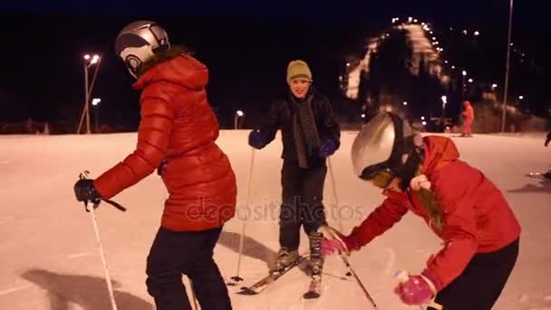 冬の夜に丘の上の女性と子供のスキーヤー — ストック動画