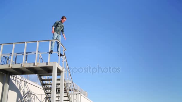 Mann Steht Auf Geländer Auf Dach Und Breitet Die Hände — Stockvideo