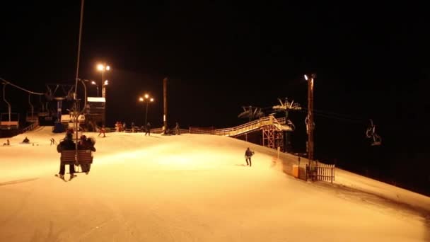 夜ケーブルカーの移動とスキー場に多くのスキーヤーと追跡 — ストック動画
