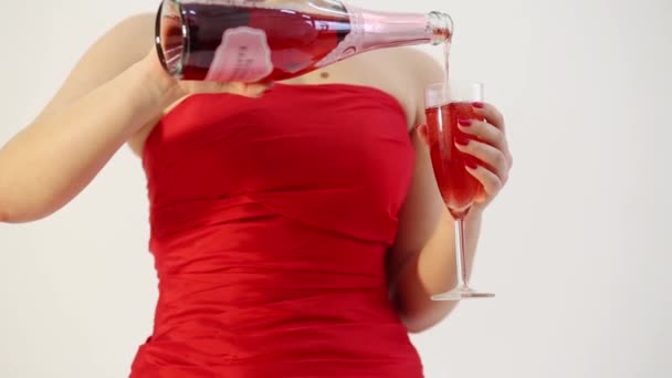 穿着红色连衣裙的女人把红酒倒进玻璃杯里喝 — 图库视频影像