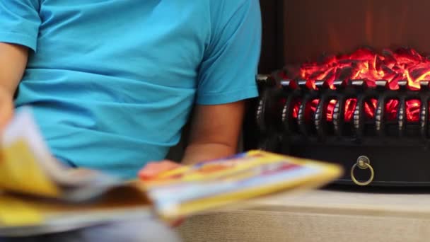 Man Sits Floor Next Fireplace Book His Hands — Stock Video