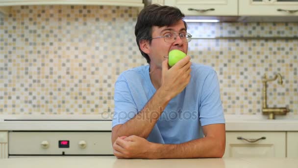 緑メガネと青い シャツ食べる男アップル — ストック動画