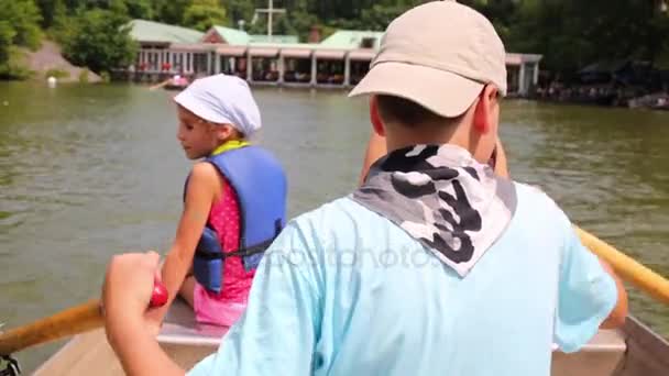 男孩桨骑在船上池塘 特写后视图 — 图库视频影像