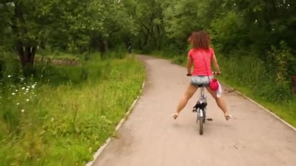 양쪽에 그녀의 다리를 떨어져 자전거를 — 비디오