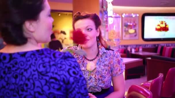 两个带着玫瑰的女人在复古餐厅的酒吧里聊天 关注正确的女人 — 图库视频影像