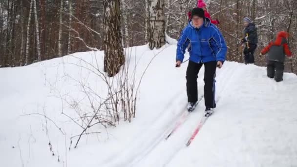 Man Glider Ner Från Snow Hill Skogen Bredvid Tre Barn — Stockvideo