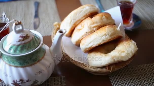 Hand Takes Bun Wicker Basket Table Glasses Tea Teapot — Stock Video