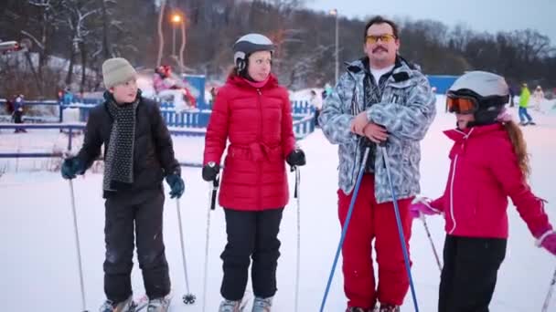 Une famille de quatre skieurs pose en hiver sur la piste — Video