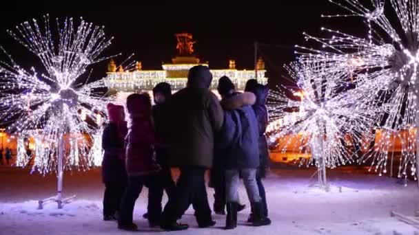 七成人和孩子一起在冬天晚上在 Vdnh 附近玩耍 — 图库视频影像