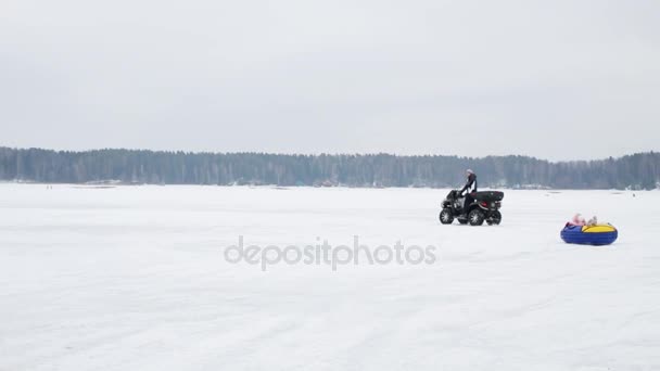Человек Квадроцикле Катается Счастливый Ребенок Снежном Поле Зимой — стоковое видео