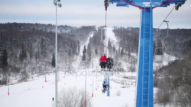 Frau und Junge steigen im Winter auf Seilbahn — Stockvideo
