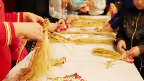 成人和儿童的手在桌上制作稻草民俗娃娃 — 图库视频影像