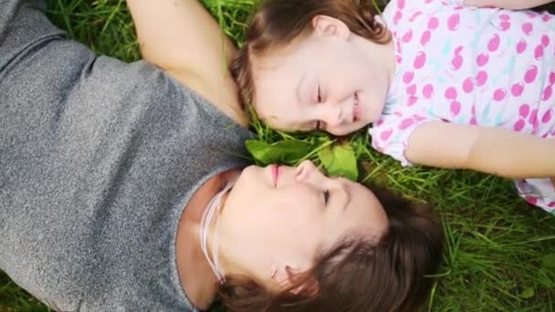 かわいい女の子と彼女の母親の芝生の上にあるし お互いを見る — ストック動画