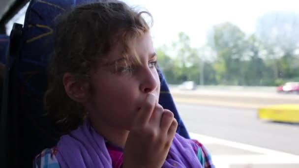 Girl Looks Out Window Bus Snacking — Stock Video