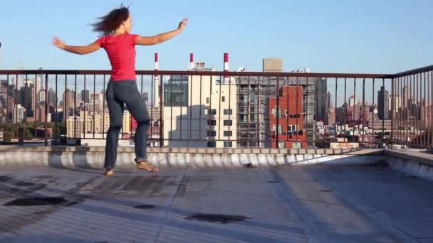 朝の青空に対して屋根の上回転若い女性の踊り — ストック動画