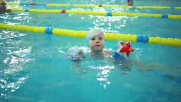 Μικρό Αγόρι Στο Φουσκωτό Περιβραχιόνια Κολυμπά Μεγάλη Εσωτερική Πισίνα — Αρχείο Βίντεο
