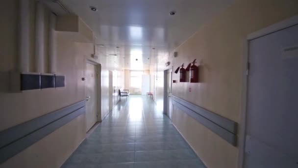 Mouvement dans le couloir avec des portes à l'hôpital. Texte sur la porte, mur : sortie, chirurgie 
