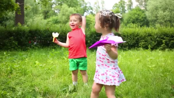 小逗人喜爱的女孩和男孩戏剧与纸飞机在夏天公园 — 图库视频影像