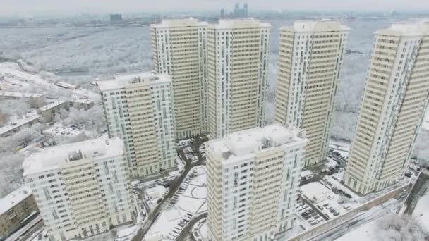 冬の日に雪で覆われた都市の景観に対して背の高い家 航空写真ビュー — ストック動画