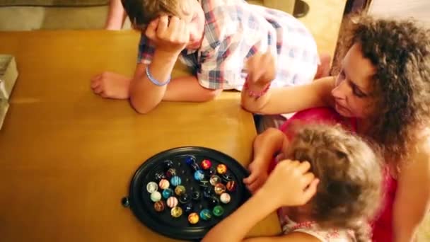 妇女与二个孩子玩游戏与五颜六色的橡胶球在桌上 — 图库视频影像