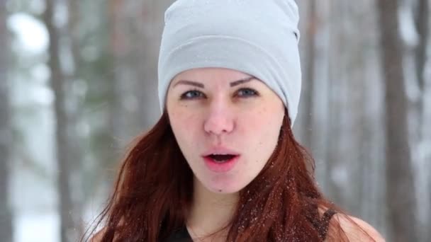 特写红头发的年轻女孩在针织帽子呼吸沉重后 在雪冬林锻炼 — 图库视频影像
